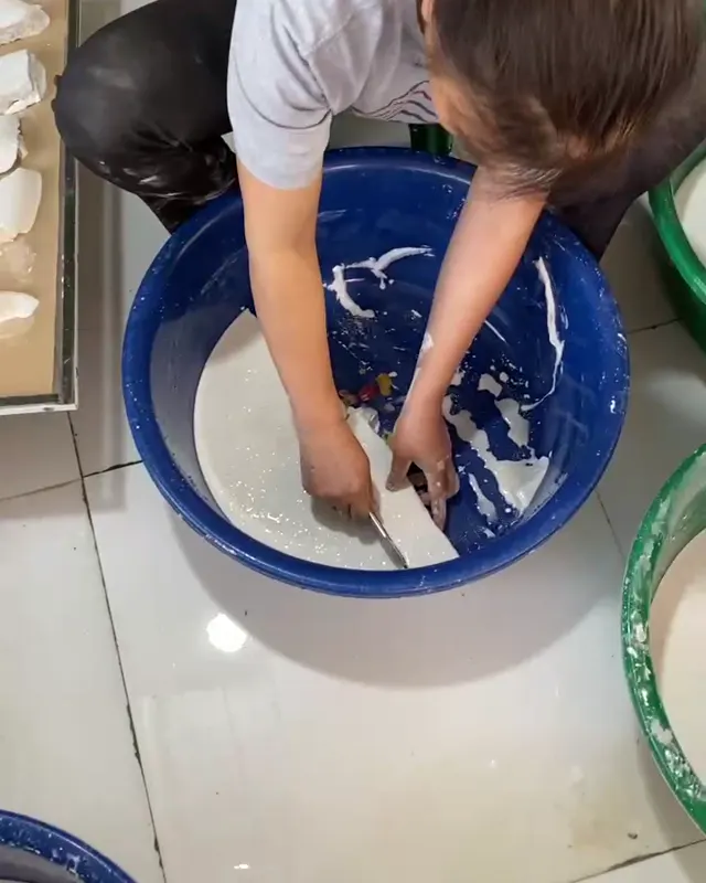 Hand-filtering kudzu starch in a basin